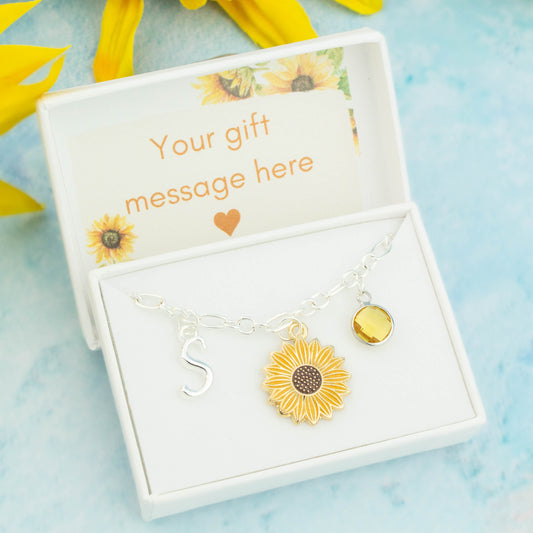 Yellow enamel sunflower charm bracelet with an initial and birthstone. Presented in a gift box with a personalised message insert.