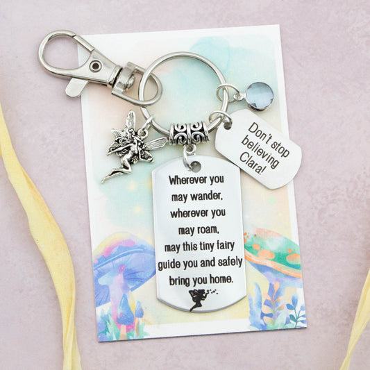 This shows the fully personalised travel Fairy keyring which includes the silver Fairy charm, the engraved quote tag which reads: “Wherever you may wander, wherever you may roam, may this tiny Fairy guide you and bring you safely home” a birthstone and a mini engraved gift message tag. It also has a clasp to attach to a bag.