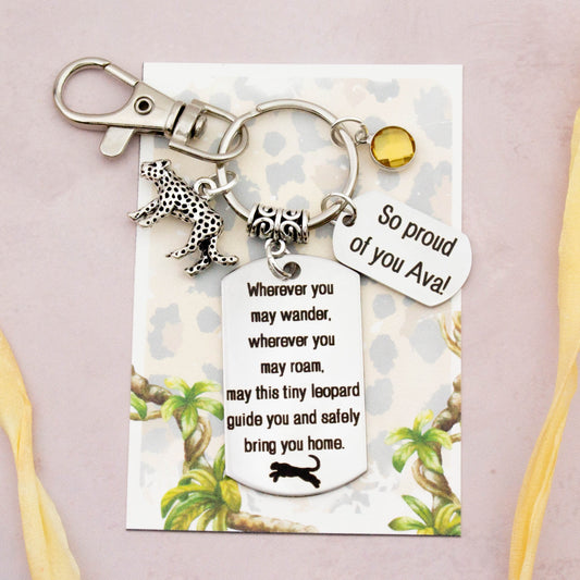 This shows the fully personalised travel leopard keyring which includes the silver leopard charm, the engraved quote tag which reads: “Wherever you may wander, wherever you may roam, may this tiny leopard guide you and bring you safely home” a birthstone and a mini engraved gift message tag. It also has a clasp to attach to a bag.