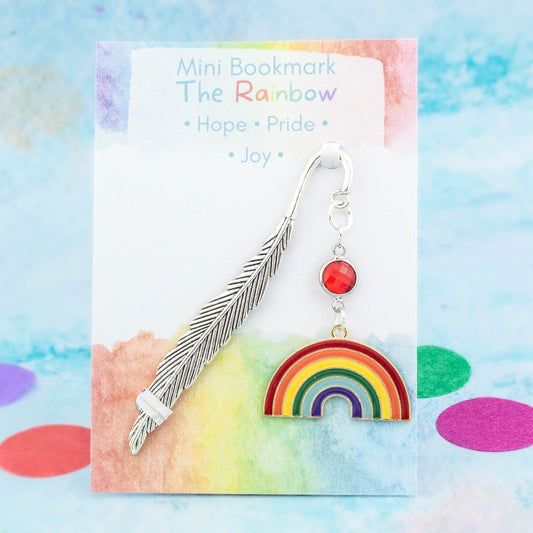 A big rainbow charm bookmark. The metal bookmark is in the shape of a feather and it has a crystal connector between it and the charm. The bookmark is backed onto a card with the symbolic meanings of the rainbow - hope, pride and joy.