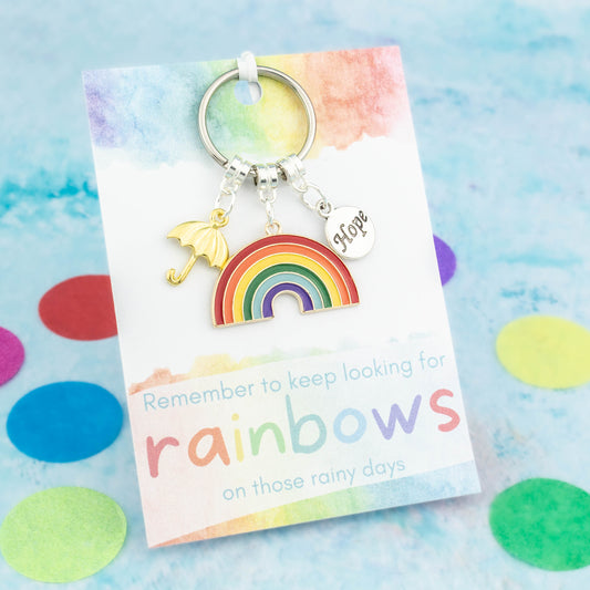A rainbow of hope gift keyring. It comes with three charms, a big rainbow, a silver hope and a gold umbrella. The sentiment card reads "Remember to keep looking for rainbows on those rainy days"!