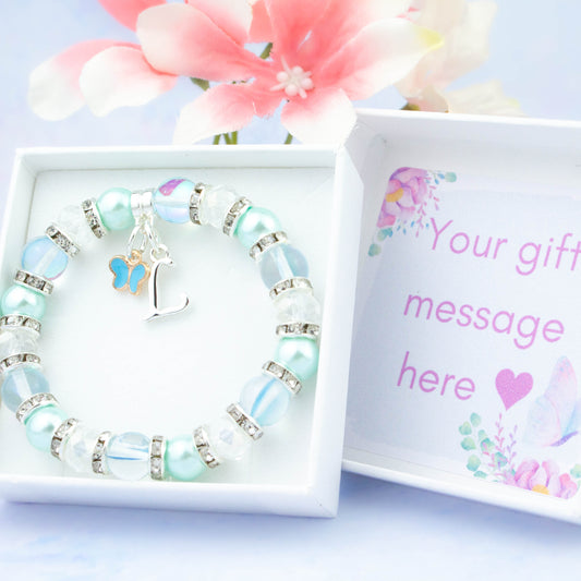 A blue butterfly charm bracelet made with baby blue beads. It is in a personalised gift box.