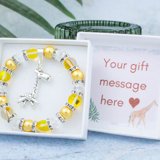 A giraffe charm bracelet made with yellow beads. It is in a personalised gift box.