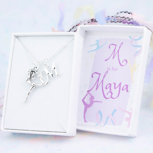 A silver chain necklace with a silver gymnast pendant and initial charm. The gift box is personalised with the name of the recipient.