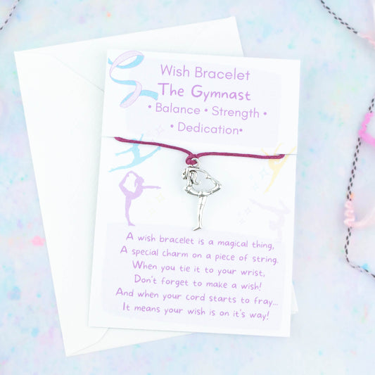 A cord with a gymnast charm backed onto a card. The card has a little poem about making wishes with the bracelet by tying it on and letting the cord wear through.