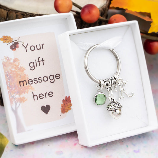 Silver acorn charm keyring with an initial and birthstone. Presented in a gift box with a personalised message insert.