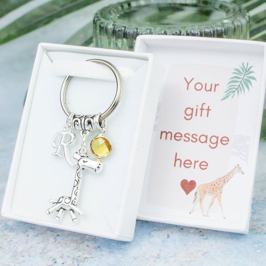 Silver giraffe charm keyring with an initial and birthstone. Presented in a gift box with a personalised message insert.