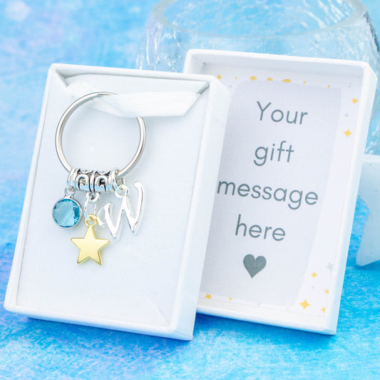 Silver gold star charm keyring with an initial and birthstone. Presented in a gift box with a personalised message insert.