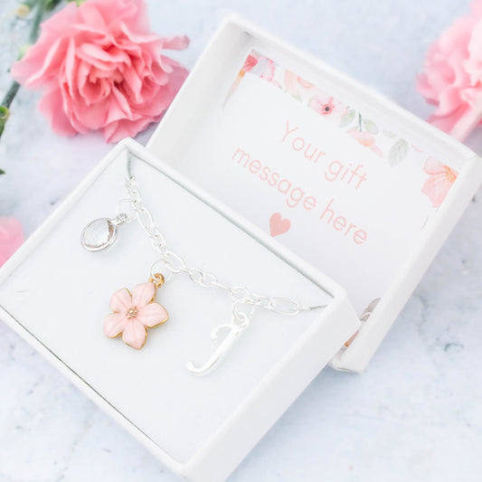 A pink flower charm bracelet for flower girls and bridesmaids. It can be personalised with an initial and birthstone and comes in a personalised gift box.