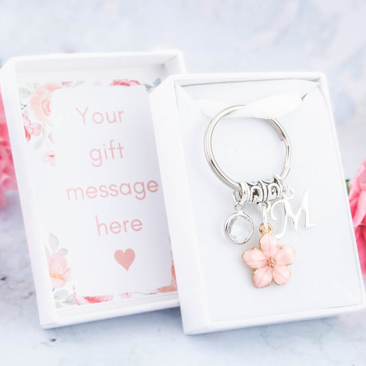 A pink flower charm keyring that can be personalised with an initial and birthstone charm. It also comes with a gift box that can have the lid insert personalised with your gift message.