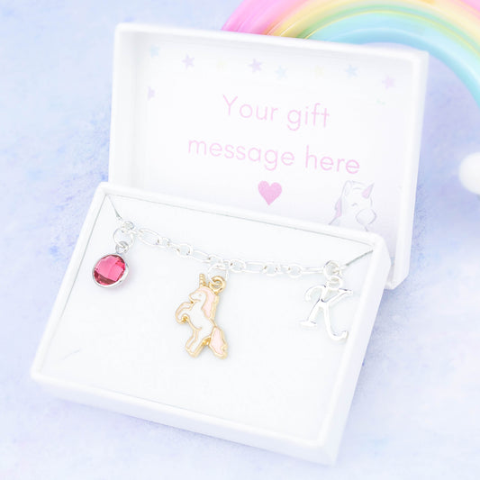 Enamel pink unicorn charm bracelet with an initial and birthstone. Presented in a gift box with a personalised message insert.