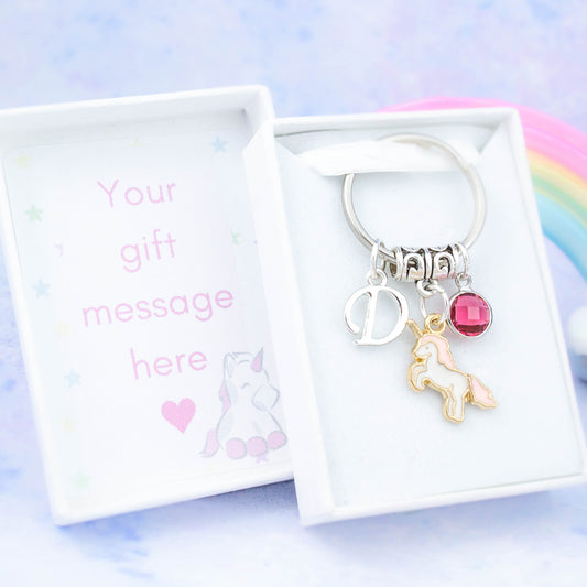 Pink unicorn charm keyring with an initial and birthstone. Presented in a gift box with a personalised message insert.