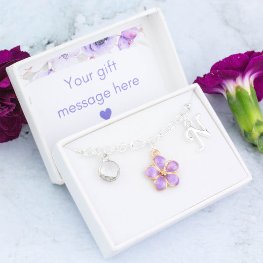 A purple flower charm bracelet for flower girls and bridesmaids. It can be personalised with an initial and birthstone and comes in a personalised gift box.