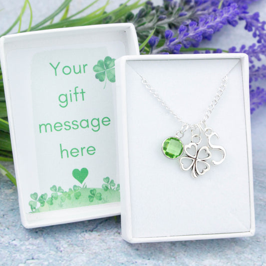 Silver four leaf clover charm necklace with an initial and birthstone. Presented in a gift box with a personalised message insert.