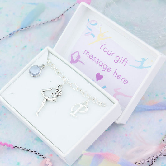 Silver gymnast charm bracelet with an initial and birthstone. Presented in a gift box with a personalised message insert.