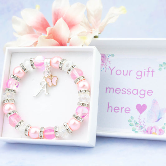 A pink butterfly charm bracelet made with pink beads. It is in a personalised gift box.