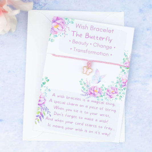 A cord with a pink butterfly charm backed onto a card. The card has a little poem about making wishes with the bracelet by tying it on and letting the cord wear through.