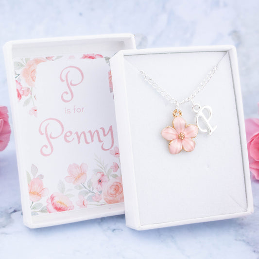 A pink flower and initial charm silver chain necklace. It comes in a white personalised gift box with the recipients name printed inside the lid.