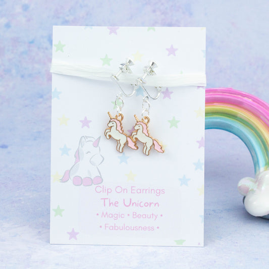Pink Unicorn Clip On Charm Earrings backed onto a card with its meanings of beauty, magic and fabulousness