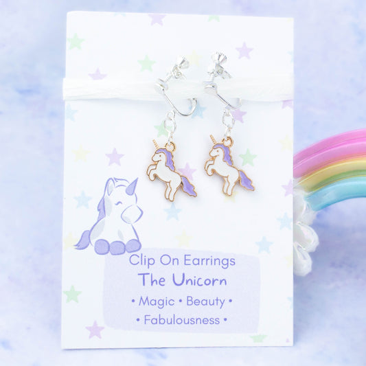 Purple Unicorn Clip On Charm Earrings backed onto a card with its meanings of beauty, magic and fabulousness