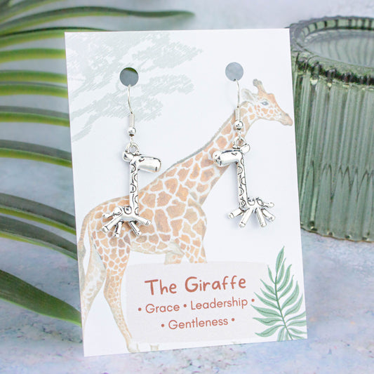 Silver 3D Giraffe Charm Earrings backed onto a card with its meanings of grace, leadership and gentleness