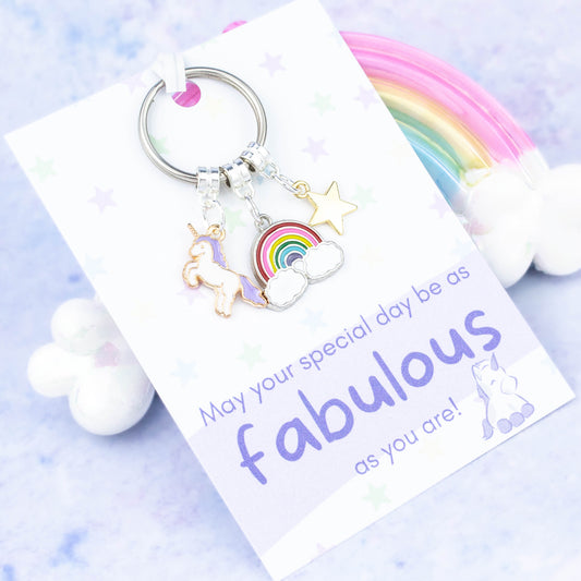 Unicorn birthday gift keyring. A unicorn, rainbow and gold star charm keychain. It is backed onto a card that reads "May your special day be as fabulous as you are"