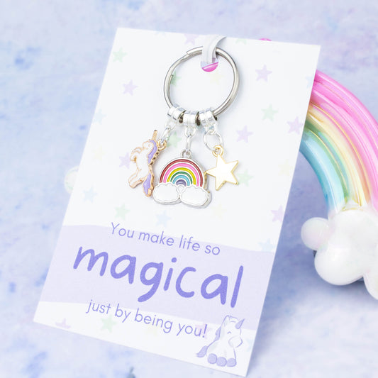 A keyring with three charms, a unicorn, a rainbow and a star. The quote on the backing card says "You make life so magical just by being you!"