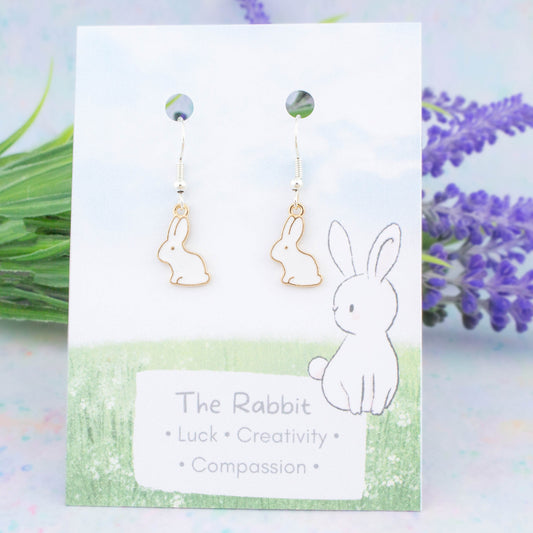 White Rabbit Charm Earrings backed onto a card with its meanings of luck, creativity and compassion.