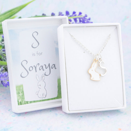 A white rabbit charm necklace personalised with a silver initial. It comes in a personalised gift box with the name of the recipient printed underneath the lid.