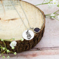 A close up of the engraving on the necklace, it shows the dark purple birthstone for February.