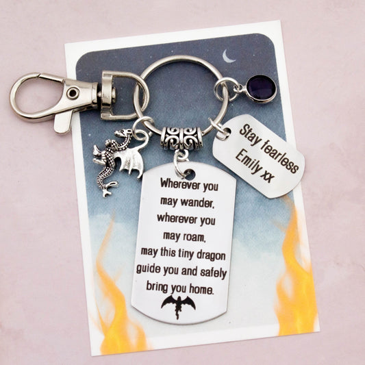 This shows the fully personalised travel dragon keyring which includes the silver dragon charm, the engraved quote tag which reads: “Wherever you may wander, wherever you may roam, may this tiny dragon guide you and bring you safely home” a birthstone and a mini engraved gift message tag. It also has a clasp to attach to a bag. 