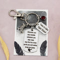 This shows the fully personalised travel raven keyring which includes the silver raven charm, the engraved quote tag which reads: “Wherever you may wander, wherever you may roam, may this tiny raven guide you and bring you safely home” a birthstone and a mini engraved gift message tag. It also has a clasp to attach to a bag. 