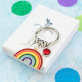 A personalised big rainbow charm keyring against a ruler.