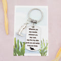 A keyring with two charms on a matching backing card. The charms are a silver otter and a quote charm that reads “Wherever you may wander, wherever you may roam, may this tiny otter guide you and bring you safely home” 