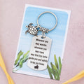 An adorable travel turtle keyring. It comes with two tags. The larger one is engraved with the quote 