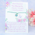 A cord with a blue butterfly charm backed onto a card. The card has a little poem about making wishes with the bracelet by tying it on and letting the cord wear through.  