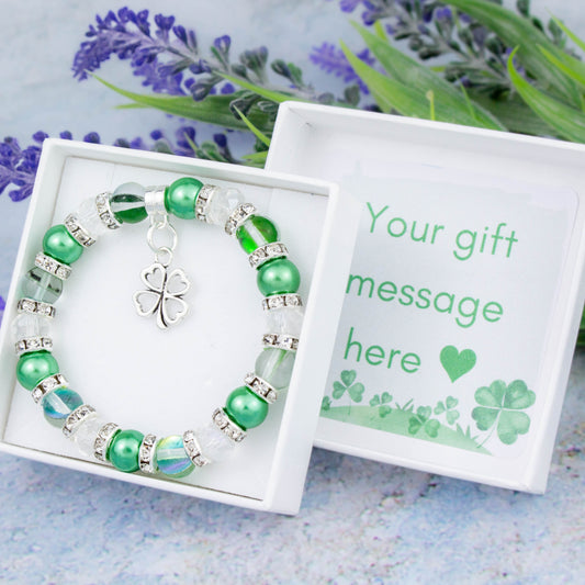A four leaf clover charm bracelet made with green beads. It is in a personalised gift box. 