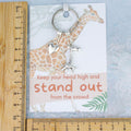 The giraffe gift keyring shown against a ruler.