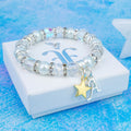 A gold star and silver initial charm bracelet with sparkly white and crystal beads. 