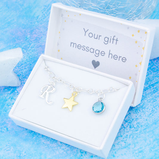 Gold star charm bracelet with a silver initial and birthstone. Presented in a gift box with a personalised message insert. 