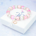 A silver and pink butterfly charm bracelet with sparkly beads. 