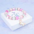 A silver and pink unicorn charm bracelet with sparkly beads.