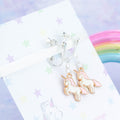 Pink Unicorn Charm Earrings on clip ons, backed onto a card with its symbolic meanings.