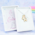 A silver chain necklace with an enamel pink unicorn pendant and initial charm. The gift box is personalised with the name of the recipient.