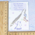 Purple unicorn charm bookmark and card shown against a ruler 