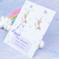 Enamel Purple Unicorn Charm Earrings on silver hooks, backed onto a card with its symbolic meanings. 