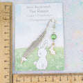 White rabbit bookmark and backing card shown against a ruler 