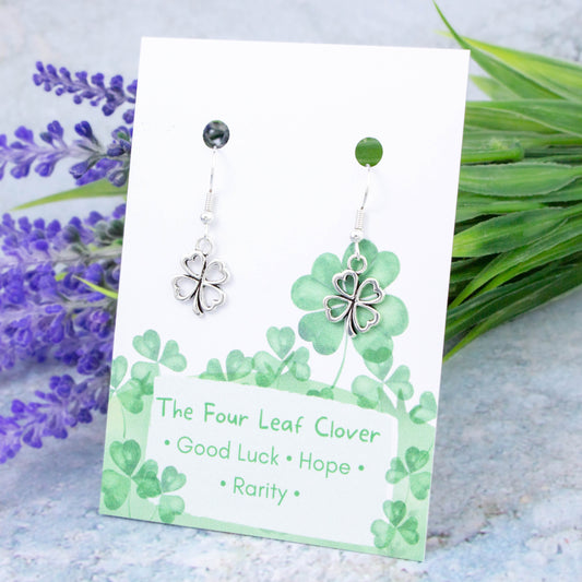 Silver Four Leaf Clover Charm Earrings backed onto a card with its meanings of good luck, hope and rarity.