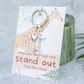 A giraffe gift, a silver keychain with a giraffe and heart charm. The card has a giraffe related pun on it.