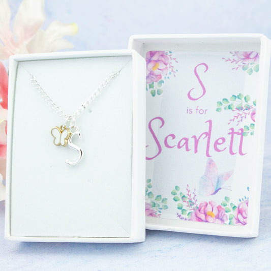 A silver chain necklace with a white butterfly pendant and initial charm. The gift box is personalised with the name of the recipient. 